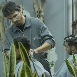 Salon detail: a stylist cutting a client's hair at a station.