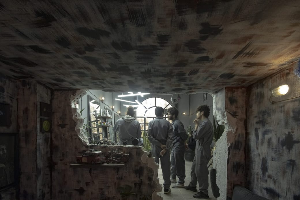 A wide view of a textured salon interior with distant figures too small to identify.