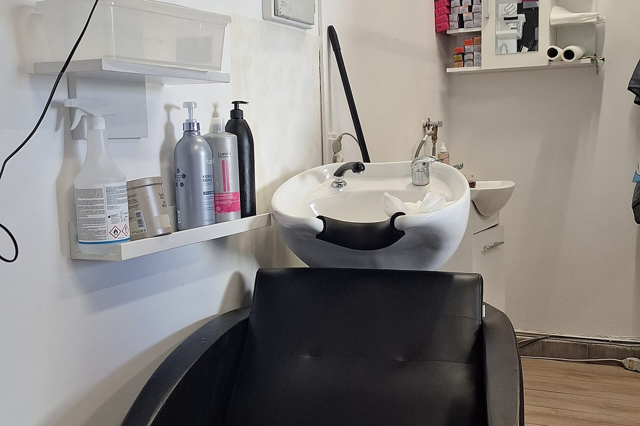 A salon shampoo chair with a backwash basin, photographed with nobody in it.