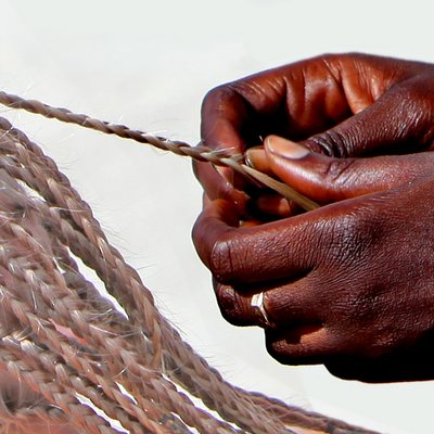 Hands braiding a long, fine plait