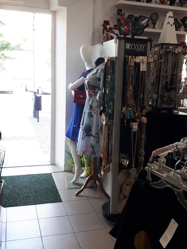 The floor of a small clothing boutique, rails and shelves