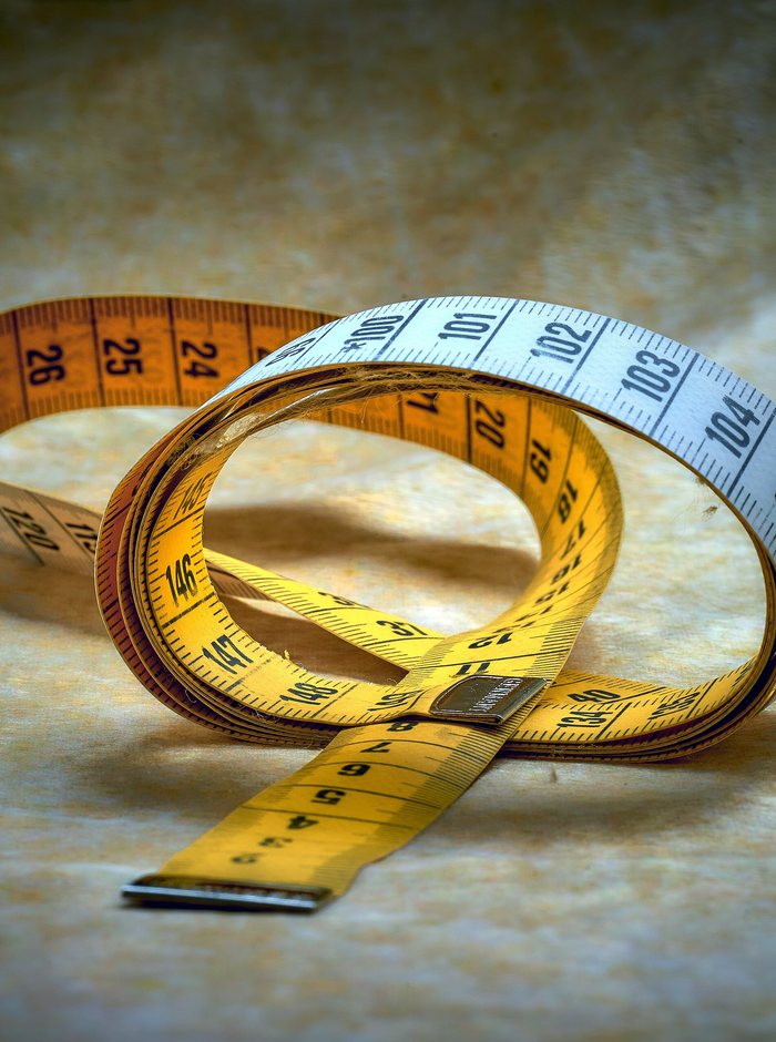 A tape measure coiled on a tailor's table