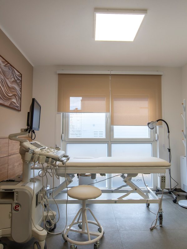 Examination room with a treatment couch, monitor and shaded window
