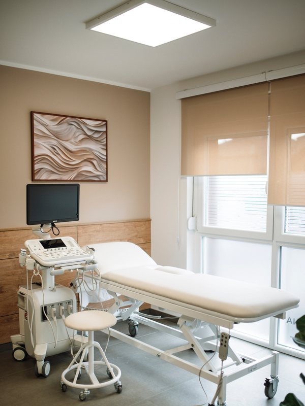 Treatment room with an adjustable couch, ultrasound unit and wall-mounted monitor