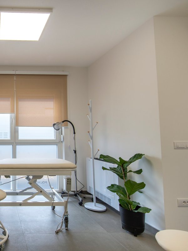 Examination room with a couch, mobile lamp and a plant beside the window