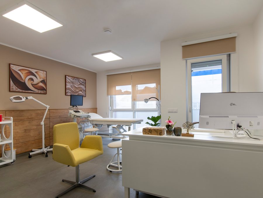 Bright treatment room with a magnifying lamp and a consulting desk