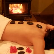 Warm dark stones laid along a person’s back.