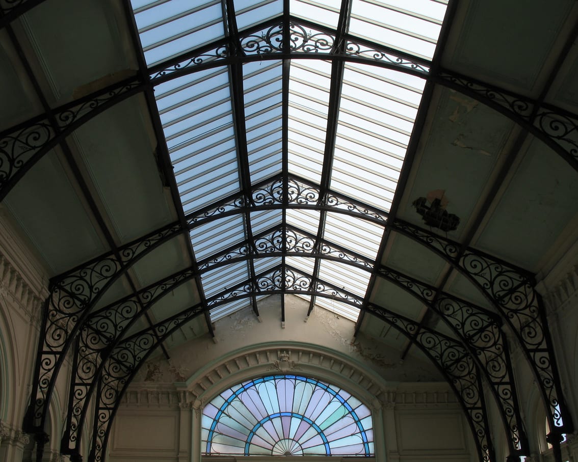 A tall spa hall with a glazed roof and pale stone walls.