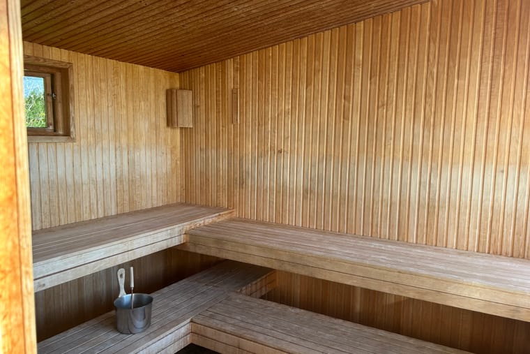 A cedar sauna interior with a slatted bench along the wall.
