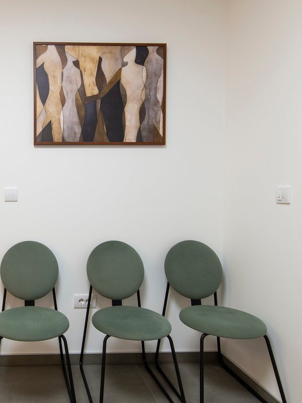 A waiting area with upholstered chairs and framed artwork