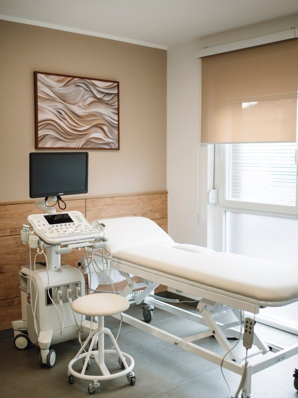 An examination room with an ultrasound unit beside a treatment couch