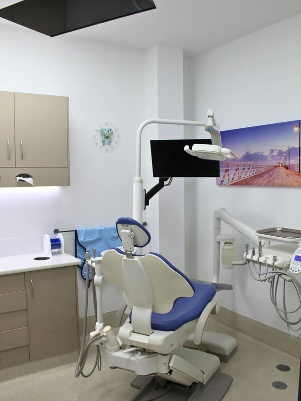A modern dental chair under the overhead light