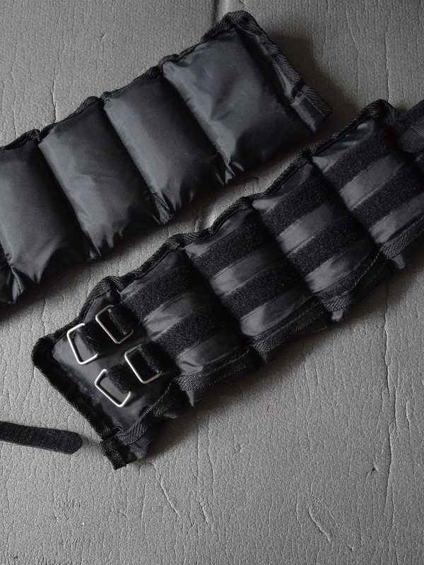 A pair of adjustable 3kg ankle weight cuffs laid out ready for use