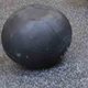A medicine ball resting on the rubber gym floor