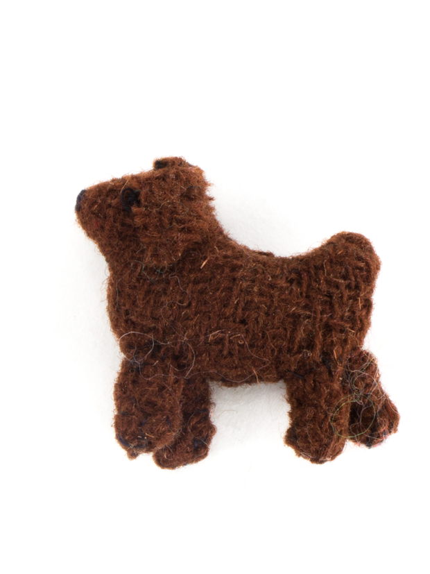 A small brown cloth toy dog photographed against a plain white ground.