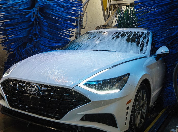 A saloon buried in white snow foam beside the blue brushes
