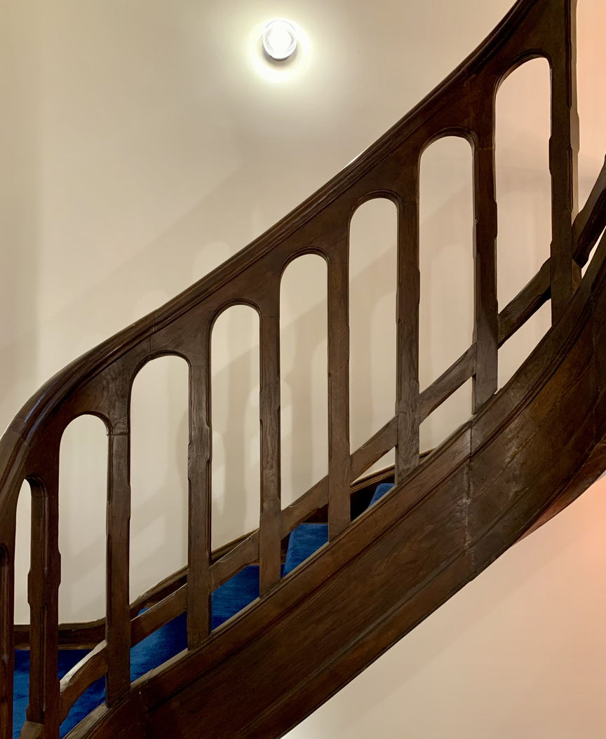 A stair detail in a Bucharest house, turned balusters and a newel post seen from the landing. An interior, not a photograph of a member of staff.