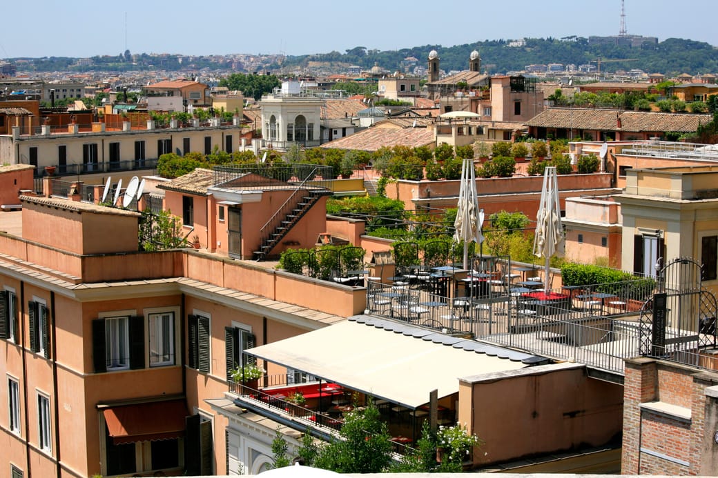 Rooftop terraces and balconies stepping back across the upper floors of city buildings.