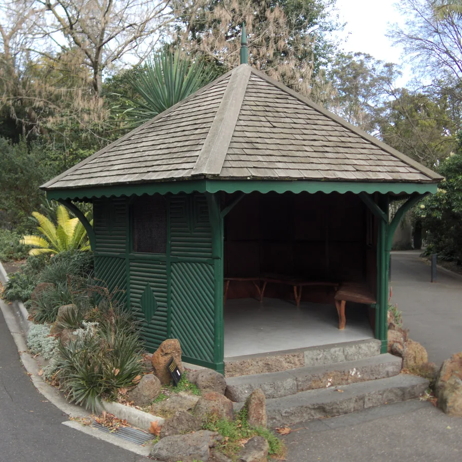 Timber garden pavilion set among shrubs