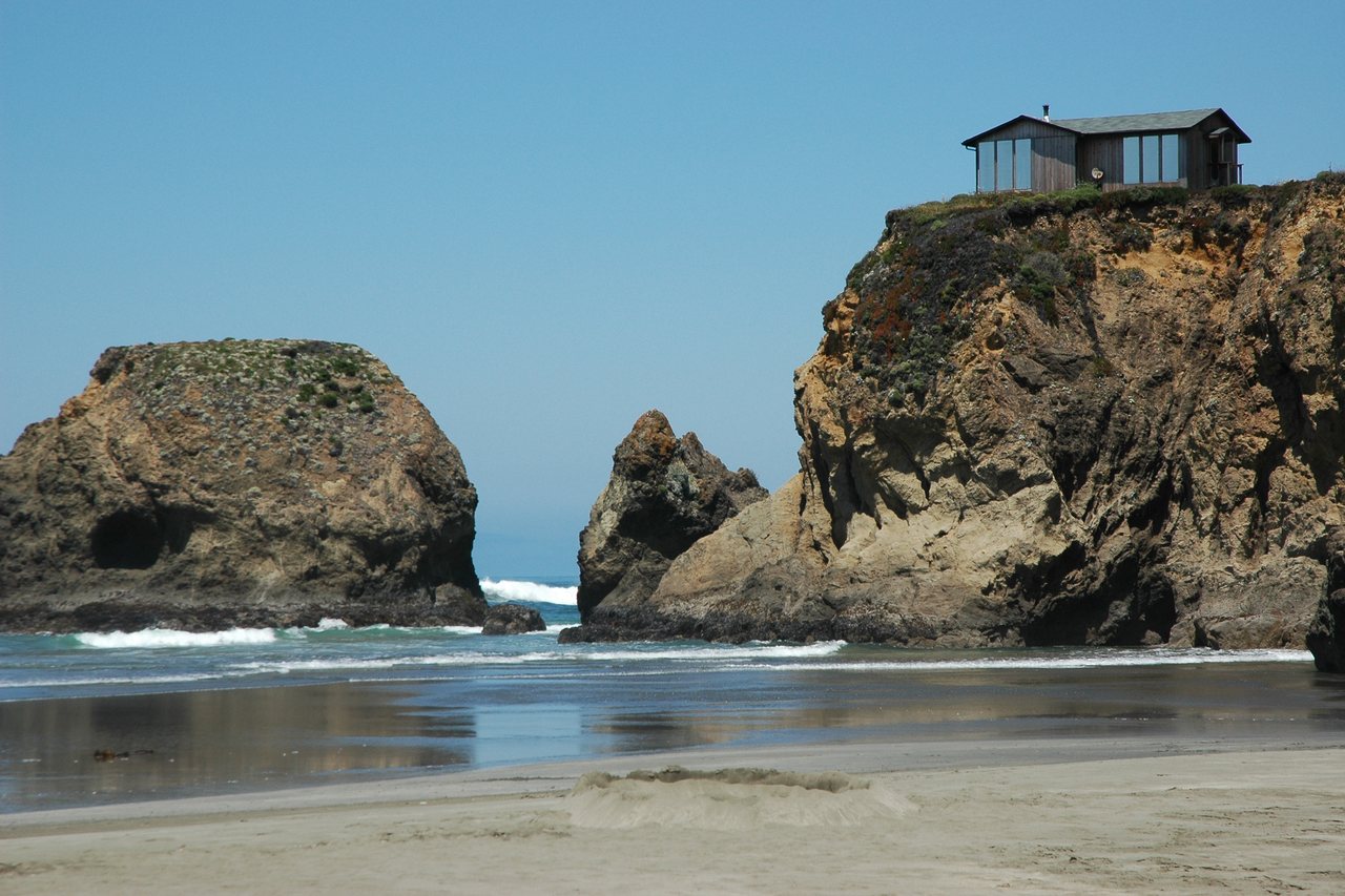 Cliffside Glass Residence — glass-walled house on the bluff above the beach