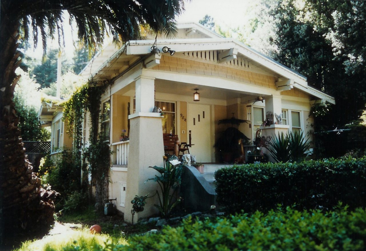 Orchard Craftsman — a white craftsman bungalow with a deep columned porch behind clipped hedges, Greenhaven, OR