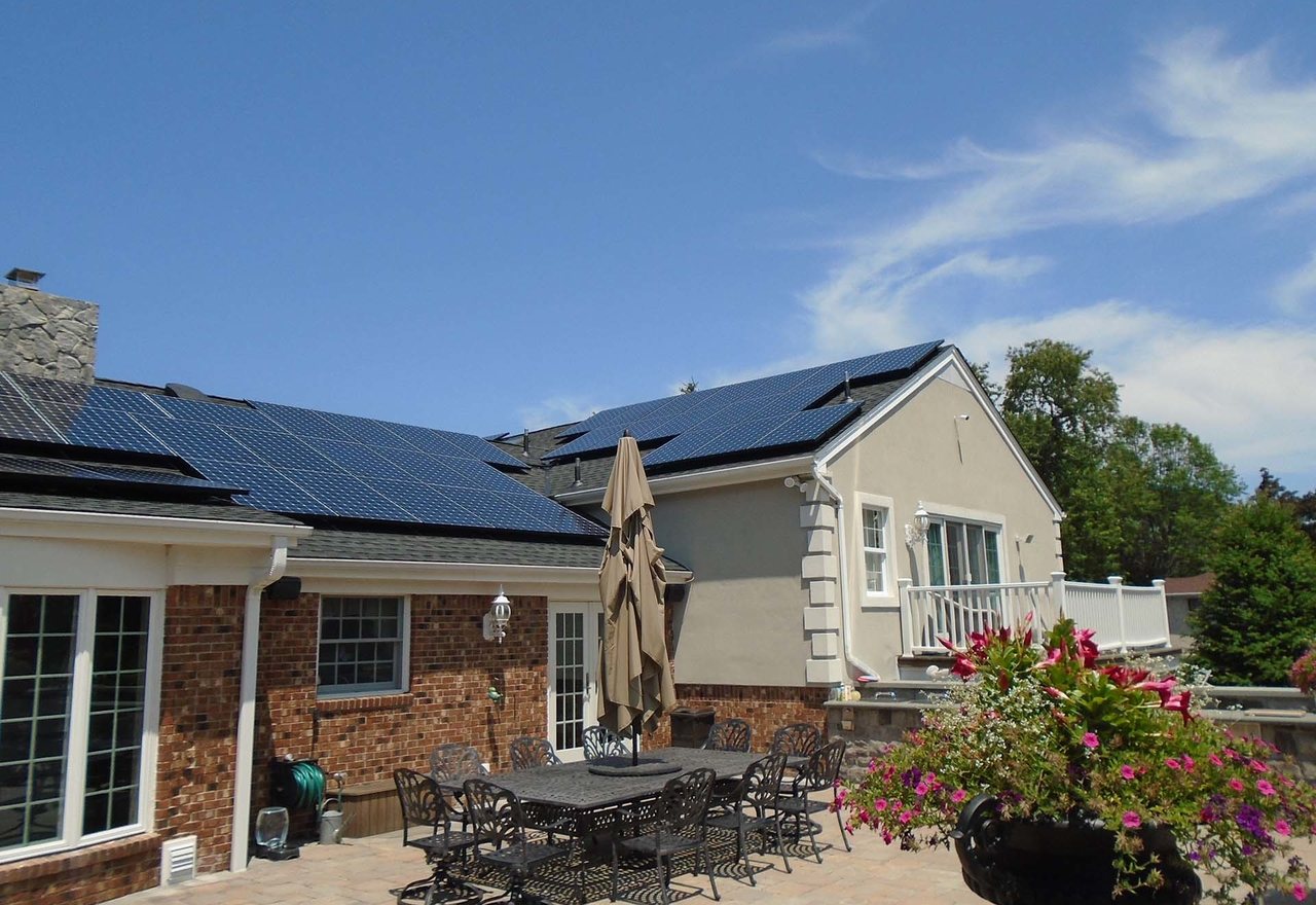Solstice Ranch — a single-storey brick and clapboard home with roof solar above a paved garden terrace, Maple Ridge, OR