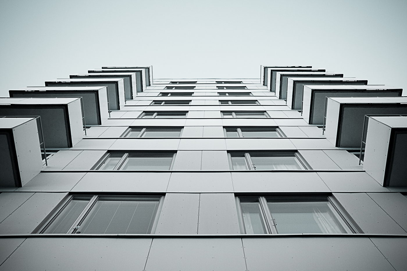 A glass high-rise seen looking straight up from the street