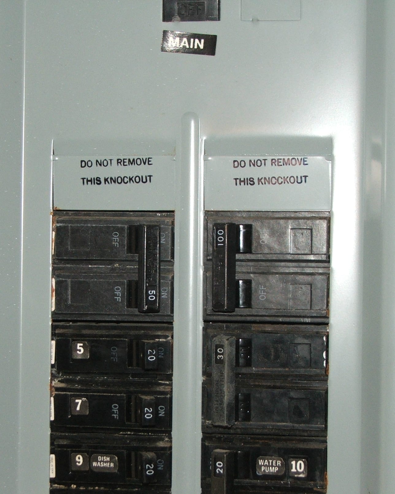 The inside of an opened panelboard, its breakers arranged in two columns with each way numbered.