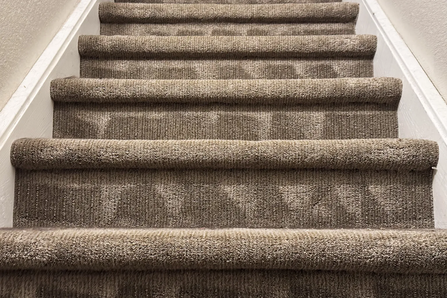 Stair carpet showing fresh vacuum lines after the closing pass