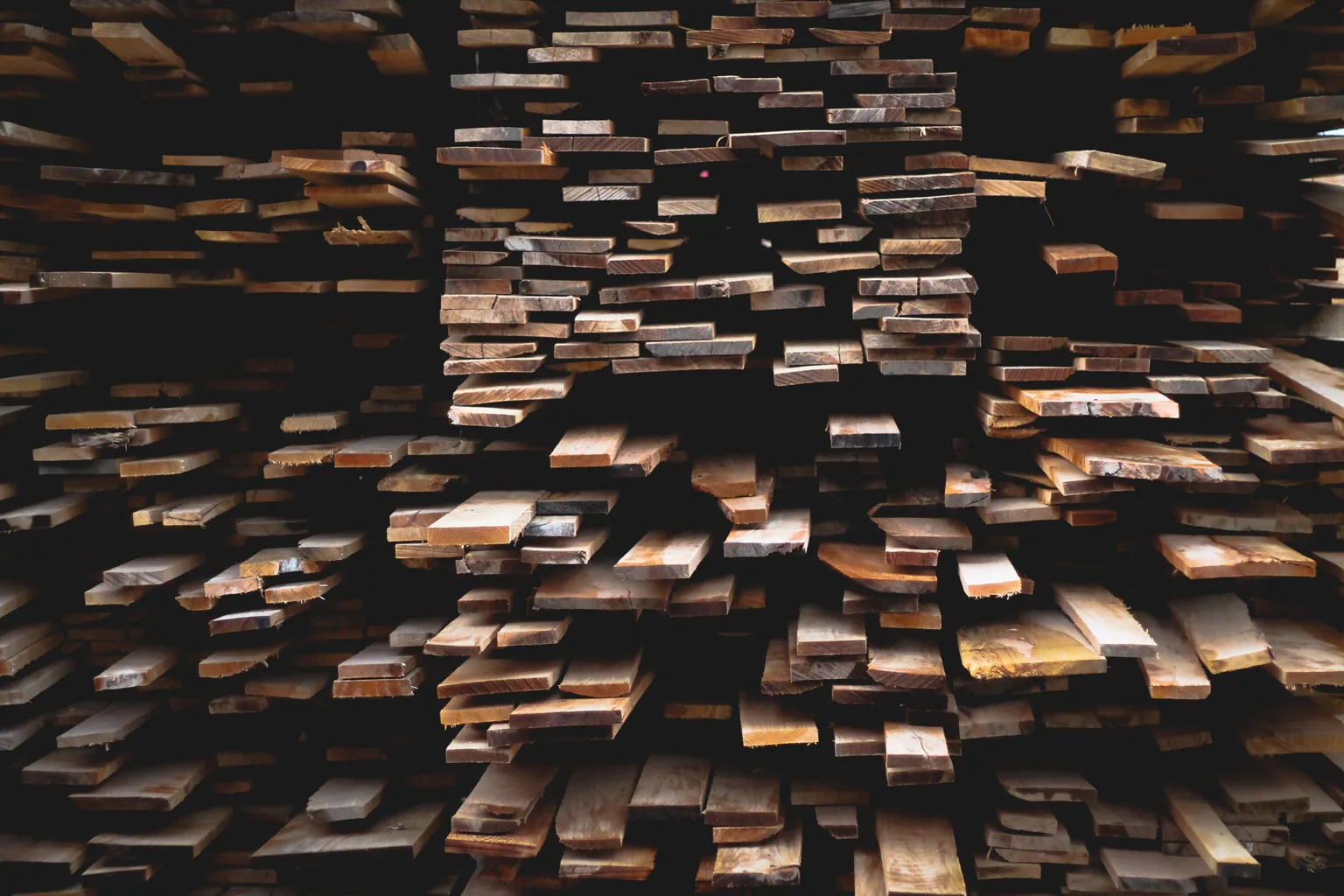 Stacked dimensional lumber sorted by length in a covered yard