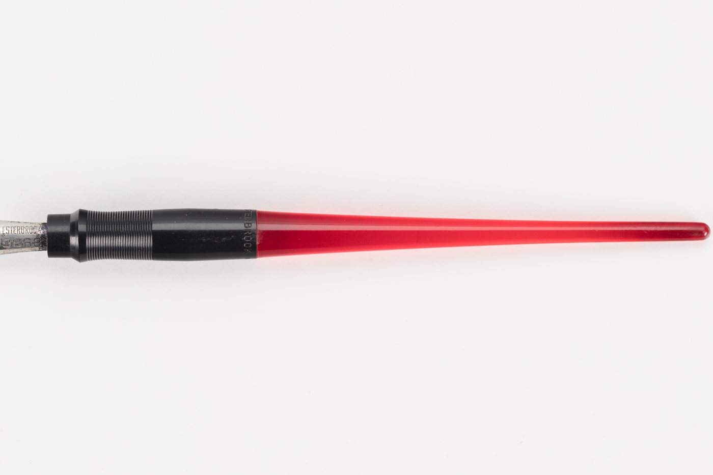 A red fountain pen lying horizontally on a plain white surface, the barrel and section shown end to end.