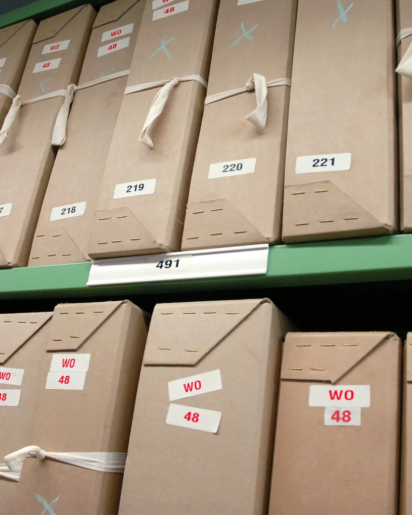 Upright crop of numbered records boxes on a storage shelf