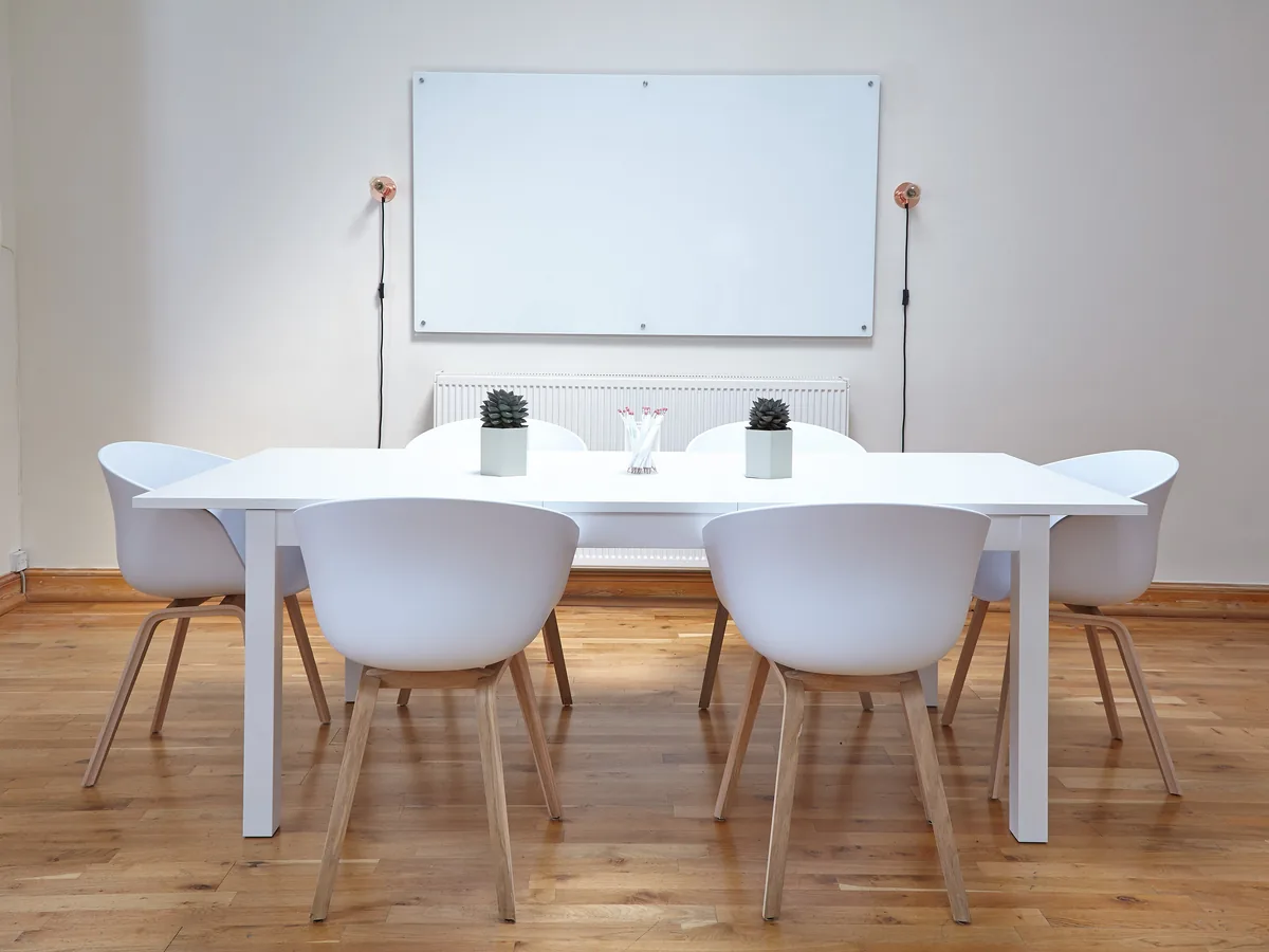 Workshop table and chairs set out in front of a whiteboard