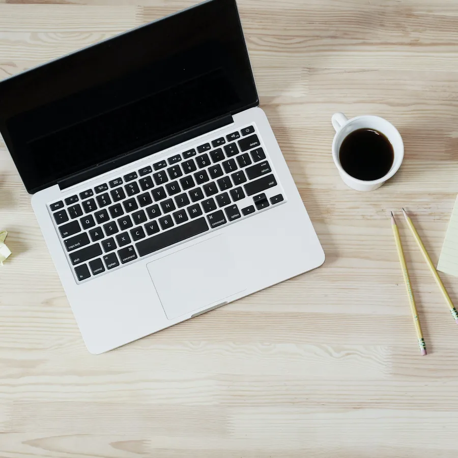 Laptop, coffee and pencils on a light working desk