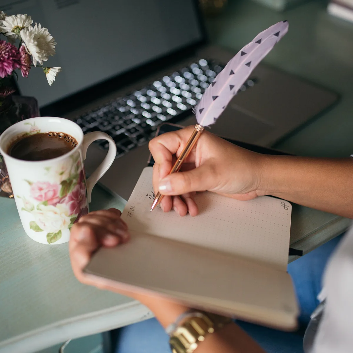 Notes written by hand beside a coffee cup and keyboard