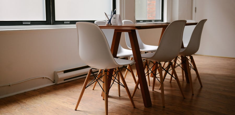 A quiet consultation room with a wooden table and chairs by a window
