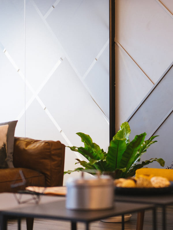A lounge corner with a leather sofa, armchair and low tables set for visitors