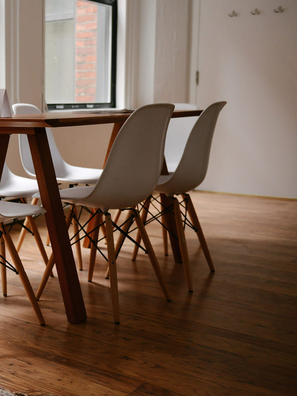 A meeting room with a wooden table and moulded chairs, ready for a review