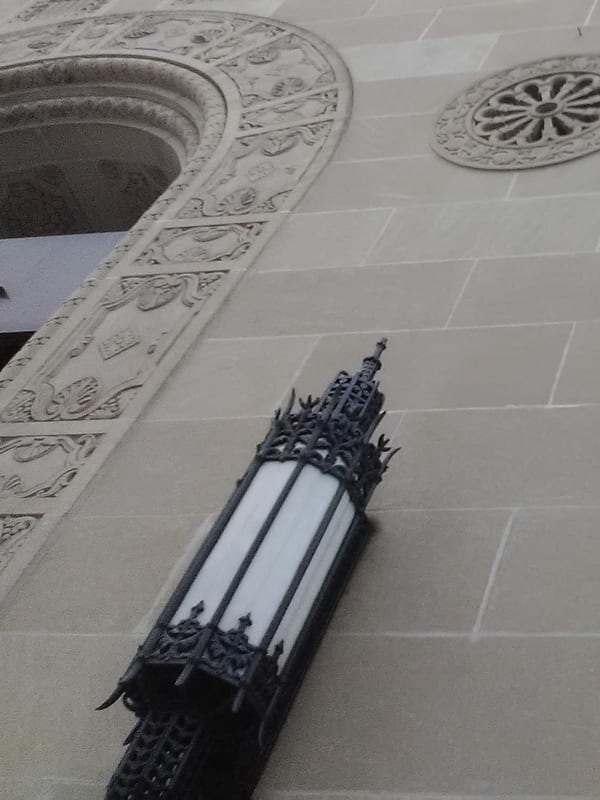 The carved limestone facade of a historic financial building, seen from the pavement