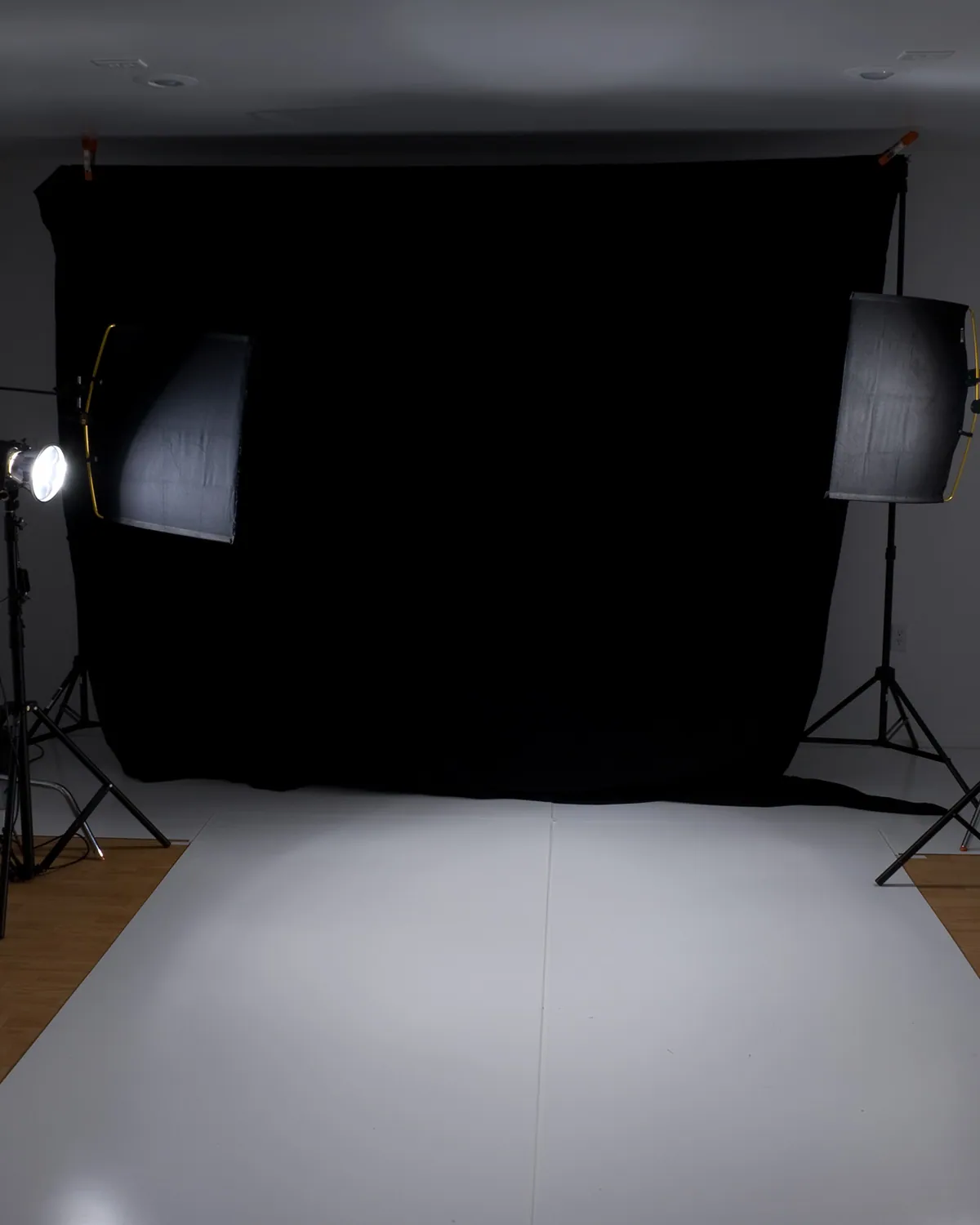 Empty portrait set with a black backdrop and two studio lights