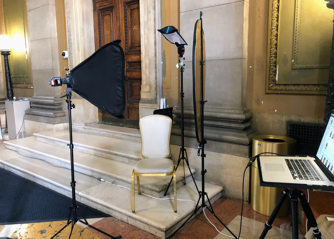 Portrait set built on location with a softbox, chair and tethered laptop
