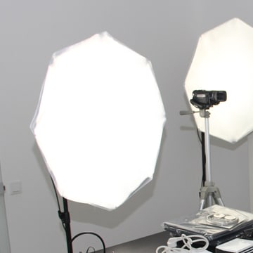 A camera up on its tripod at the shooting position, aimed between two octaboxes already fired up