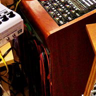 The wooden end of a console with cables running over it.