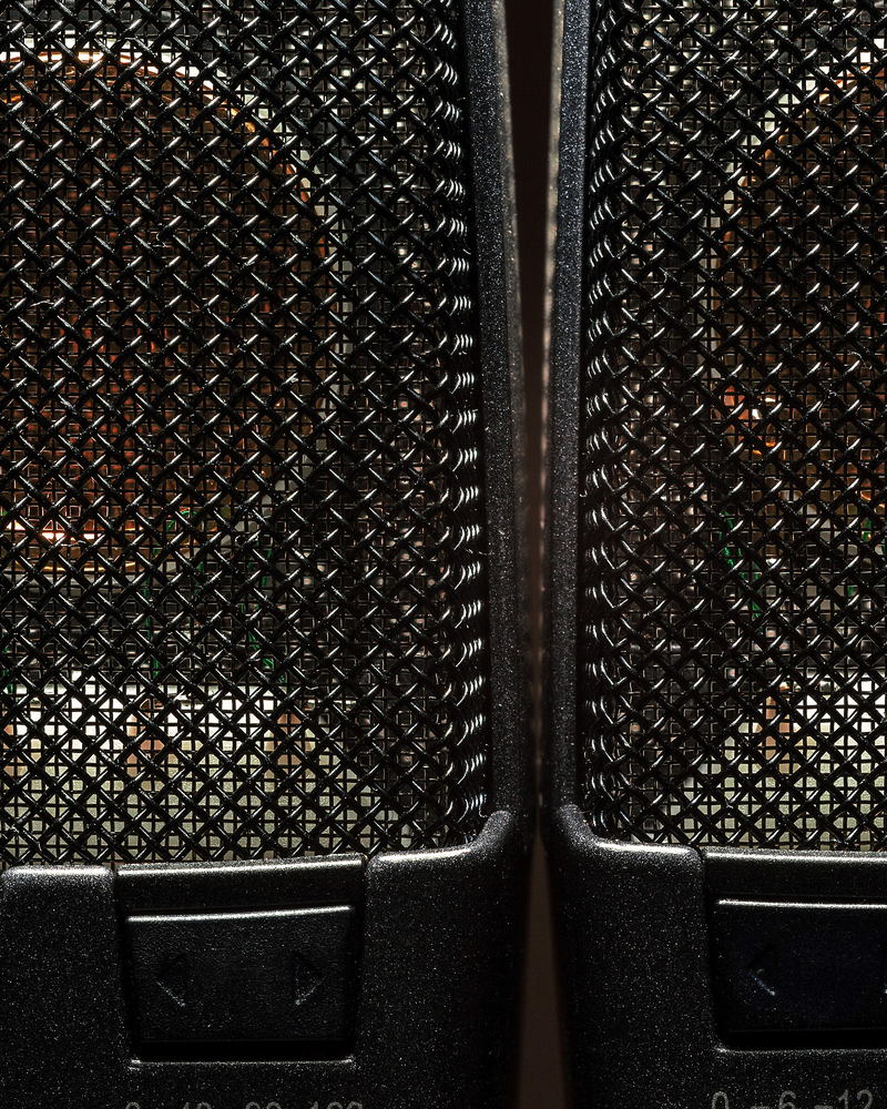 Two condenser microphone grilles meeting at their edges, photographed close.