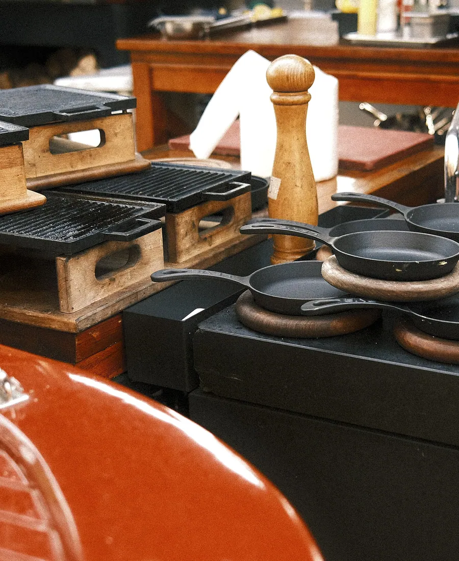 Close view of the kitchen pass with cast-iron pans and grill plates.