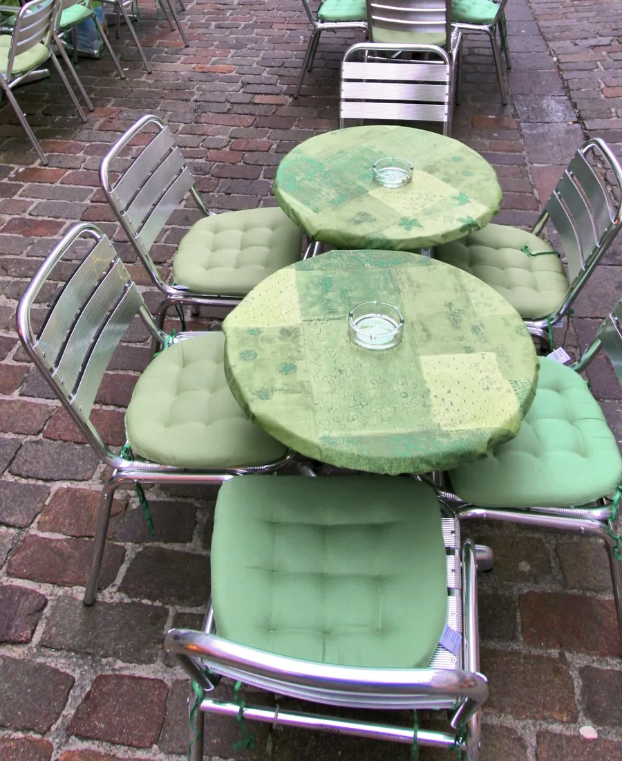 Close view of terrace tables and chairs set out on the cobbles.