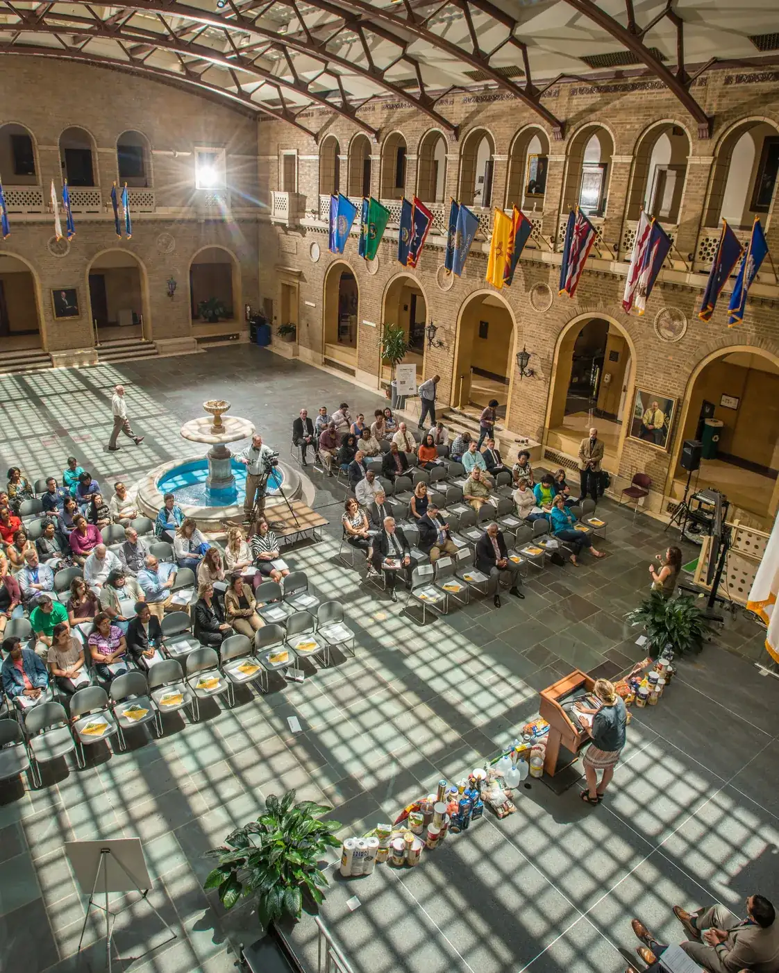 A wide overhead view of a public hall set with chairs for a community meeting
